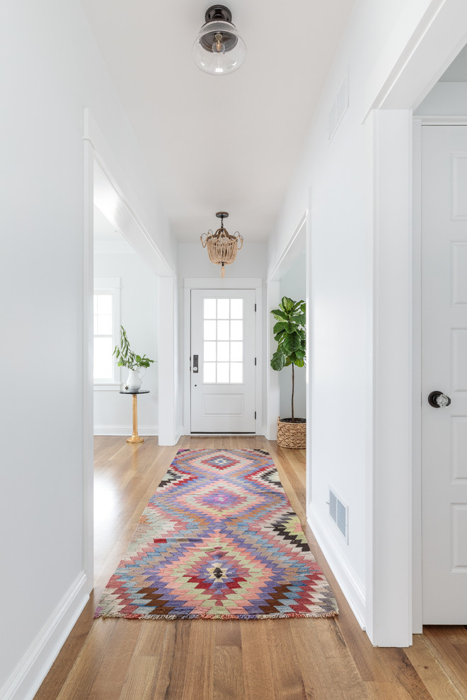 Large cottage light wood floor entryway photo in Chicago with white walls and a white front door