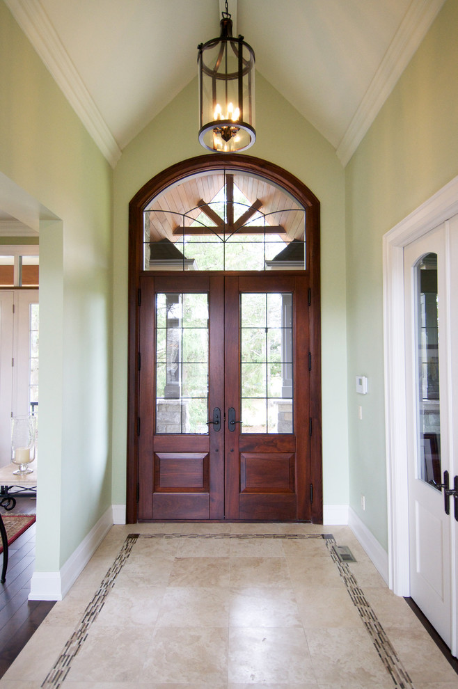 Cette image montre une porte d'entrée traditionnelle avec un mur vert, un sol en carrelage de céramique, une porte double et une porte en bois foncé.
