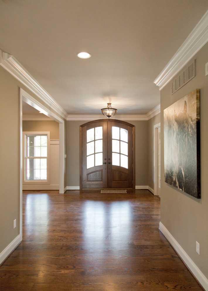Mittelgroße Klassische Haustür mit beiger Wandfarbe, braunem Holzboden, Doppeltür, hellbrauner Holzhaustür und braunem Boden in St. Louis