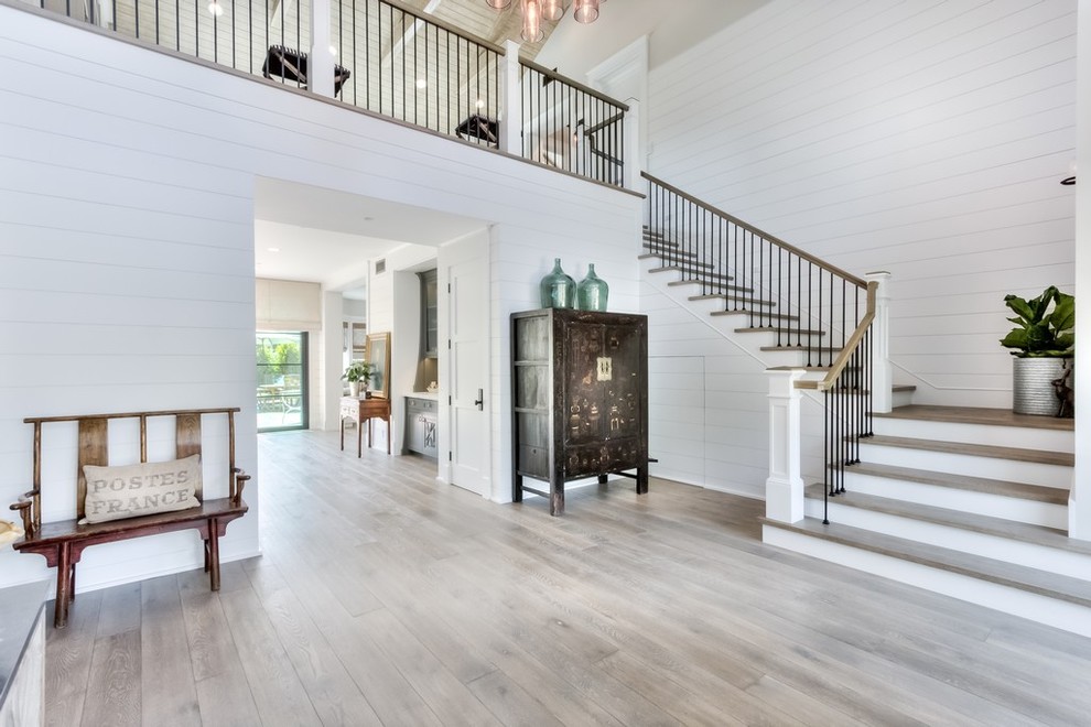 Exemple d'un grand hall d'entrée nature avec un mur blanc, parquet clair, une porte simple et une porte blanche.