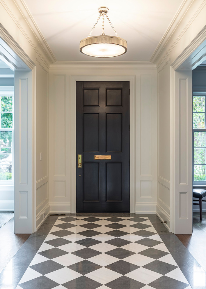 Idée de décoration pour une entrée tradition avec un couloir, un mur blanc, une porte simple, une porte noire et un sol multicolore.