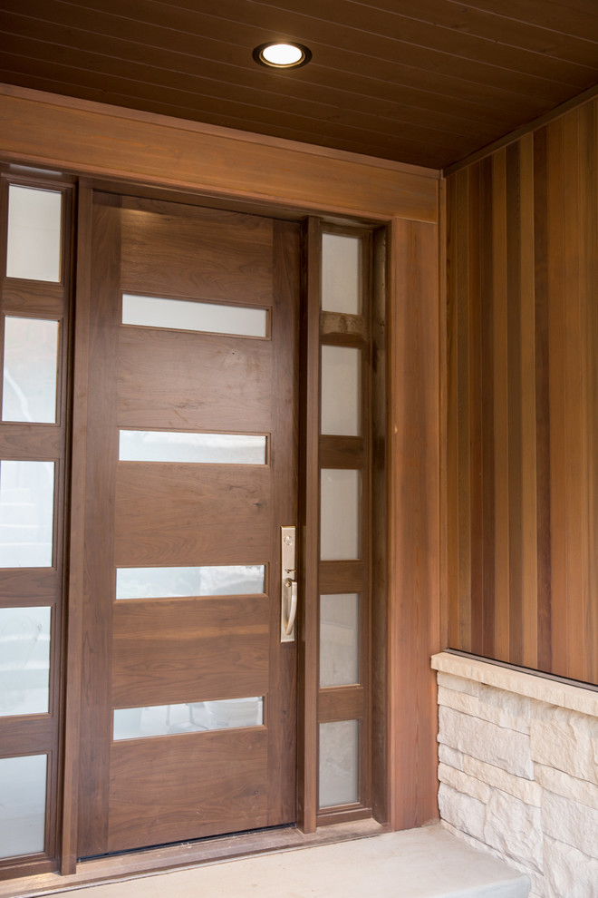 Example of a mid-sized trendy concrete floor entryway design in Phoenix with brown walls and a dark wood front door