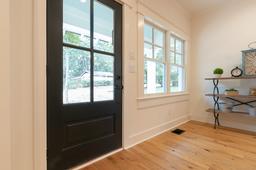 Example of a mid-sized country medium tone wood floor and brown floor entryway design in Atlanta with white walls and a glass front door