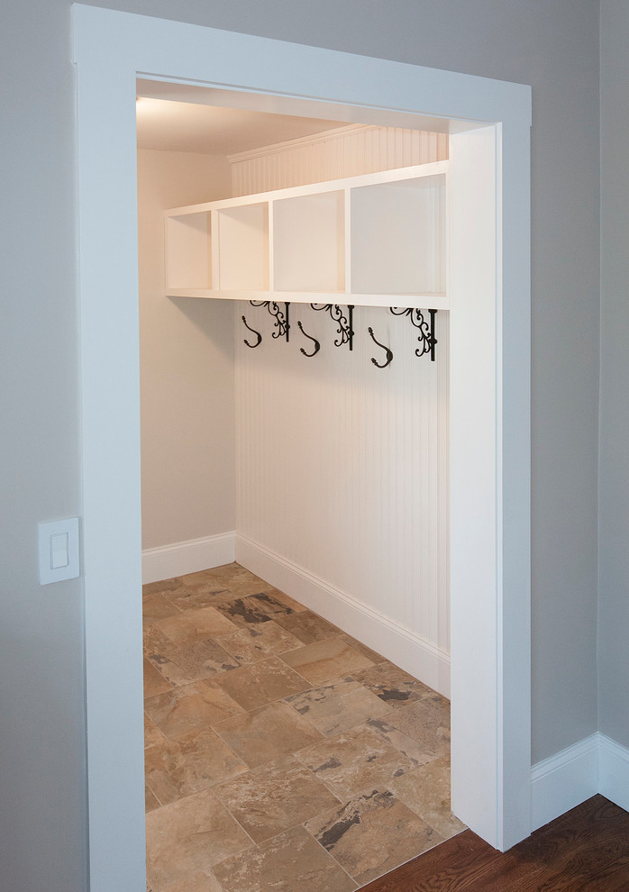 Inspiration for a mid-sized timeless porcelain tile mudroom remodel in Boston with white walls