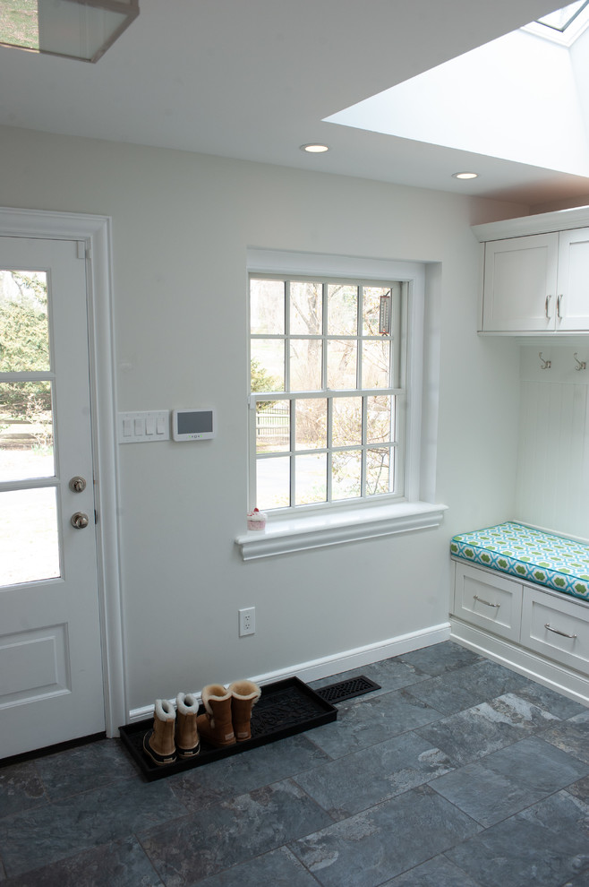 Large traditional boot room in Philadelphia with porcelain flooring, white walls and grey floors.