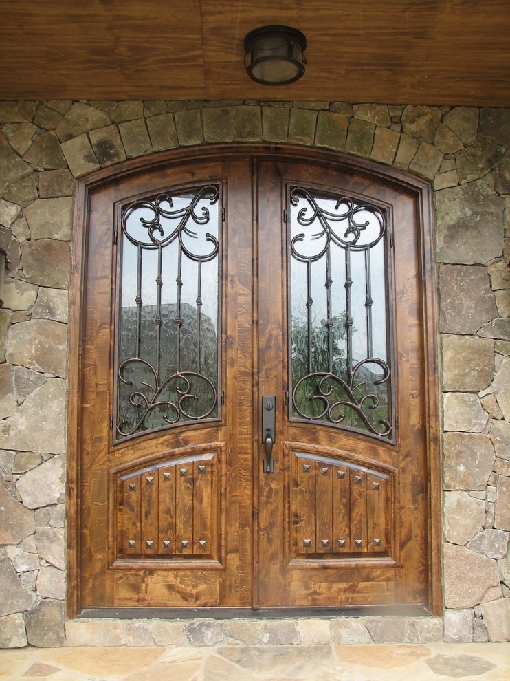 На фото: входная дверь в классическом стиле с двустворчатой входной дверью и входной дверью из дерева среднего тона с
