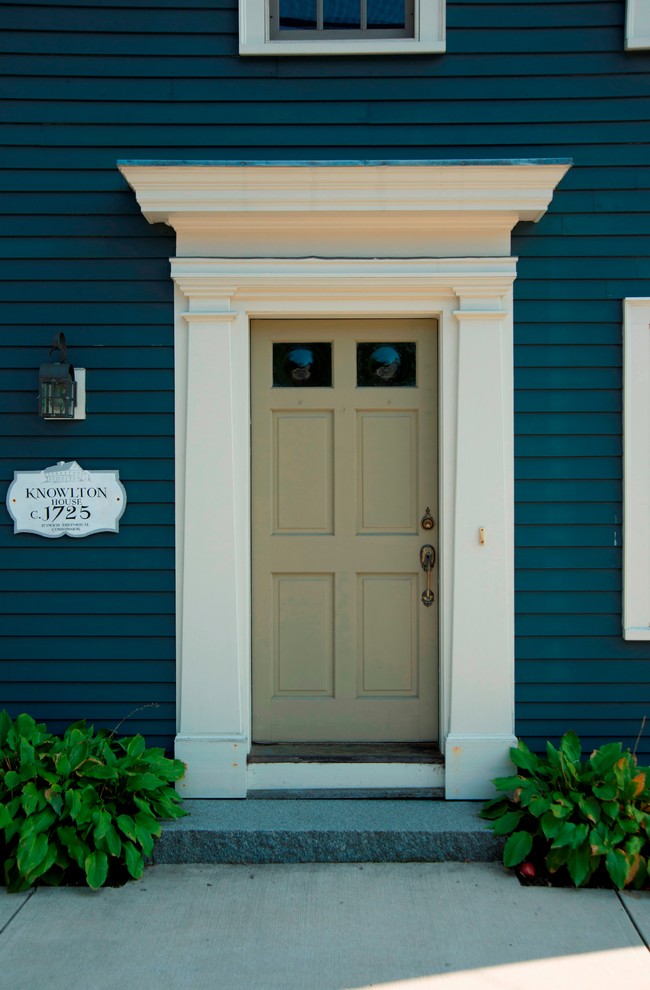 Diseño de puerta principal tradicional pequeña con suelo de granito, puerta simple y paredes azules
