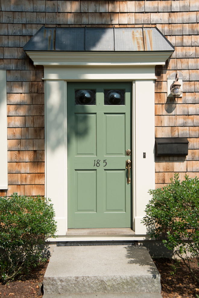Klassisk inredning av en liten ingång och ytterdörr, med beige väggar, en enkeldörr och en grön dörr