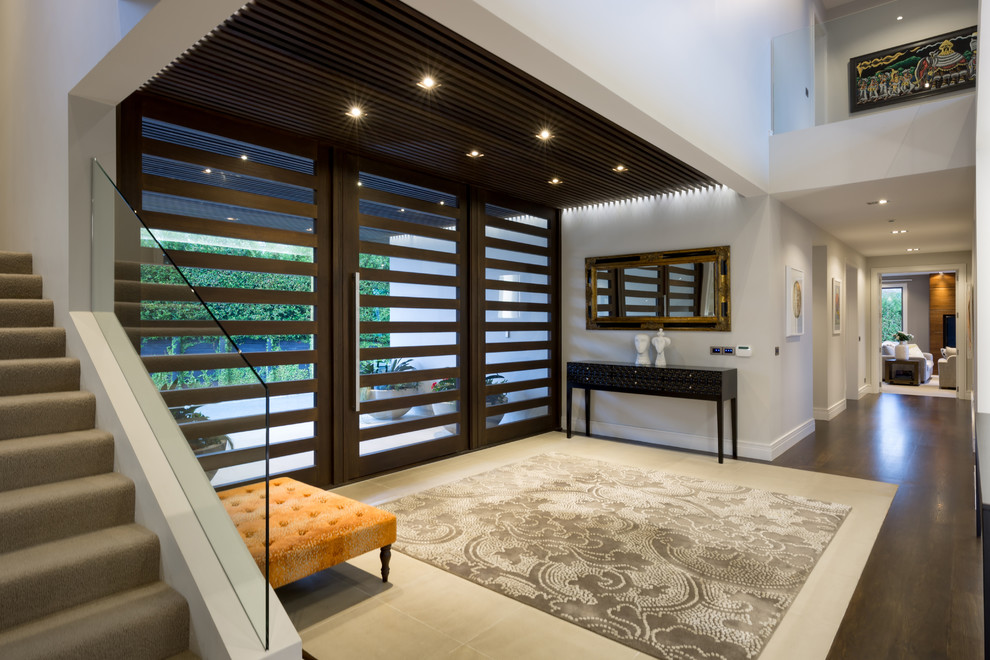 Großes Modernes Foyer mit beiger Wandfarbe, dunklem Holzboden, Doppeltür, dunkler Holzhaustür und braunem Boden in Auckland