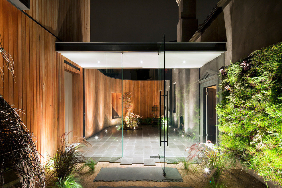 This is an example of a large contemporary front door in Melbourne with a single front door and a glass front door.