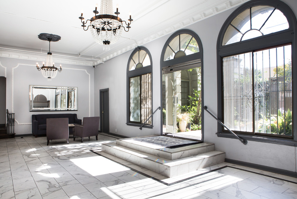 Пример оригинального дизайна: вестибюль среднего размера в современном стиле с серыми стенами, мраморным полом, одностворчатой входной дверью, черной входной дверью и белым полом