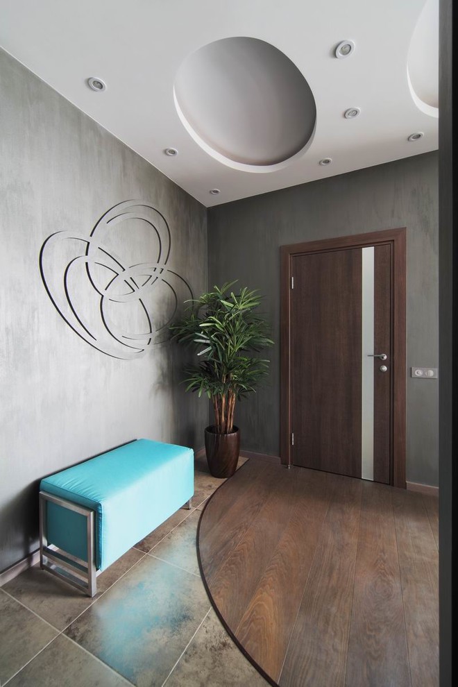 Immagine di una porta d'ingresso design di medie dimensioni con pareti grigie, pavimento in gres porcellanato, una porta marrone e pavimento marrone