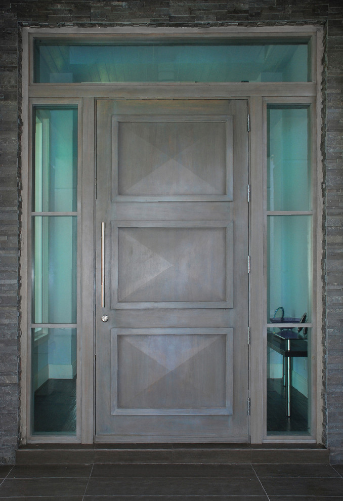 Esempio di una grande porta d'ingresso stile americano con pareti nere, una porta singola e una porta grigia
