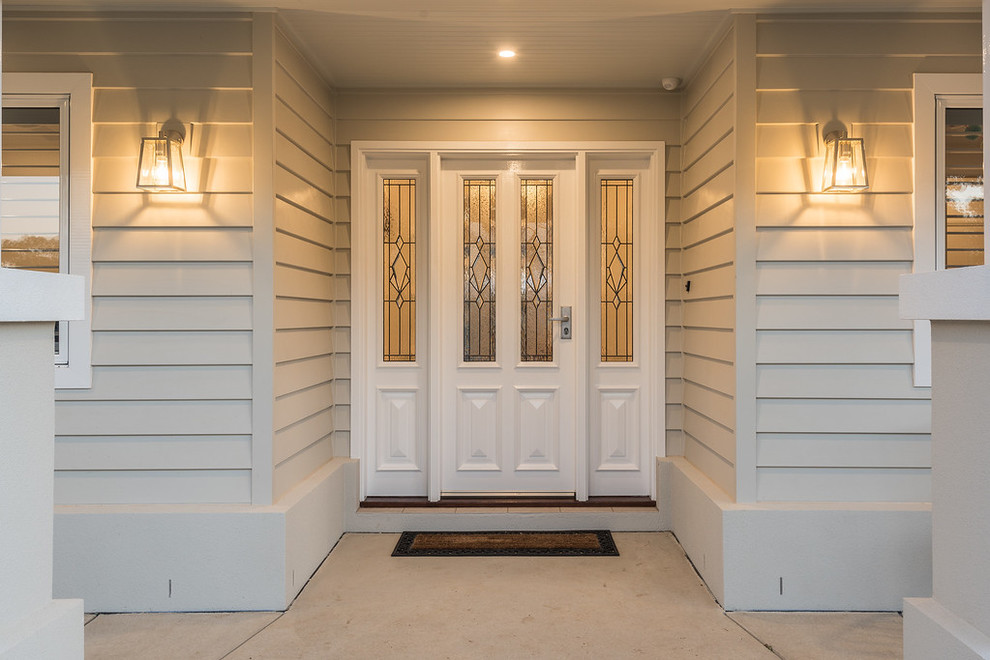 Klassisk inredning av en mellanstor ingång och ytterdörr, med grå väggar, betonggolv, en enkeldörr, en vit dörr och grått golv