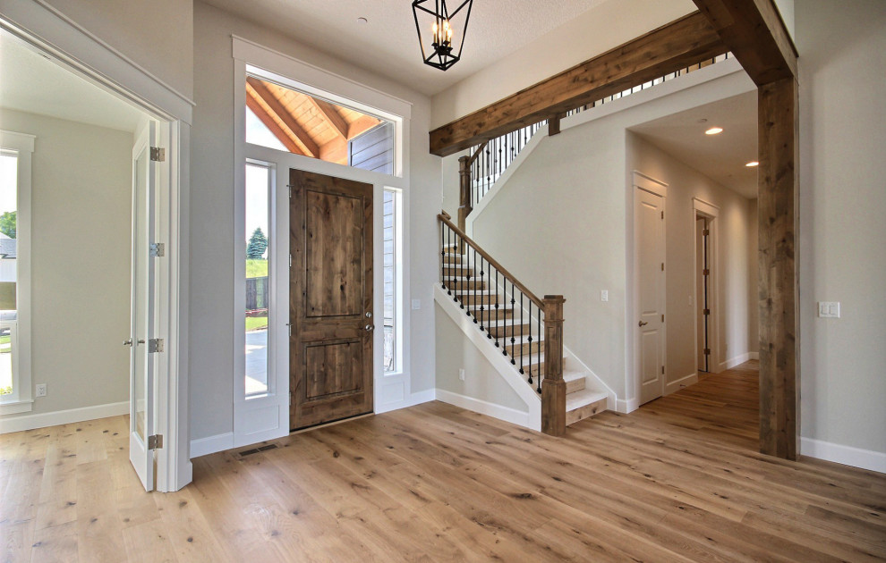 Geräumiges Klassisches Foyer mit beiger Wandfarbe, hellem Holzboden, Einzeltür, hellbrauner Holzhaustür, braunem Boden und freigelegten Dachbalken in Portland