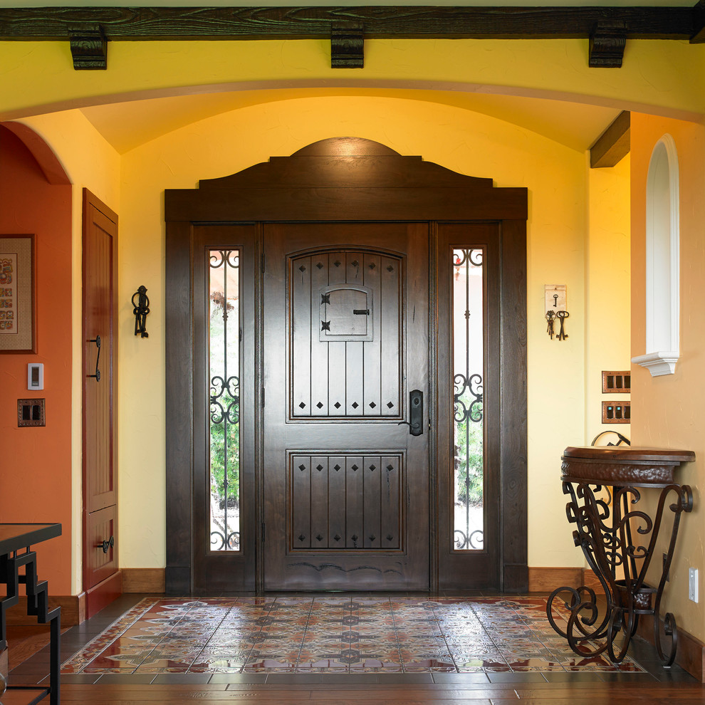 Foto di un ingresso o corridoio american style con una porta in legno scuro