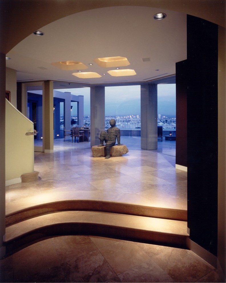 Inspiration for a large contemporary foyer in San Diego with beige walls and limestone flooring.