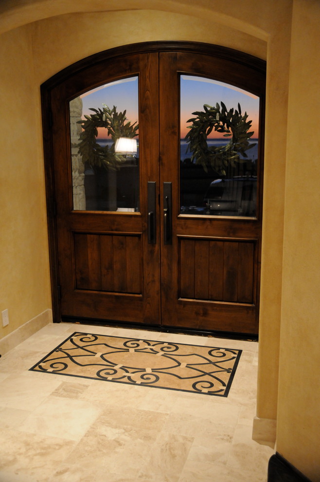 Diseño de puerta principal mediterránea de tamaño medio con paredes amarillas, suelo de baldosas de cerámica, puerta doble y puerta de madera oscura