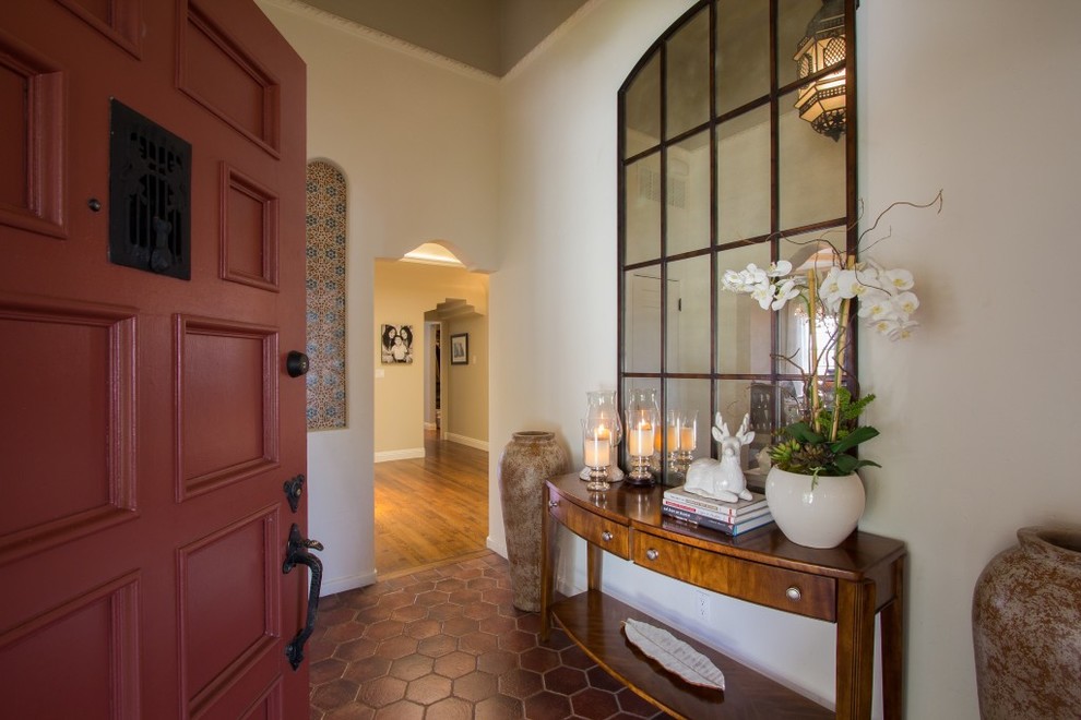 Пример оригинального дизайна: фойе среднего размера в средиземноморском стиле с бежевыми стенами, полом из терракотовой плитки, одностворчатой входной дверью, красной входной дверью и красным полом