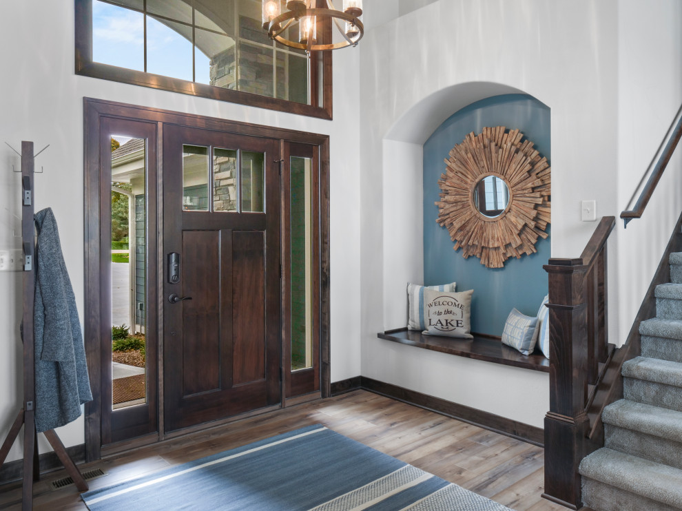 Immagine di un ampio ingresso chic con una porta singola, una porta in legno scuro, pavimento marrone, pareti grigie, pavimento in vinile e soffitto a volta