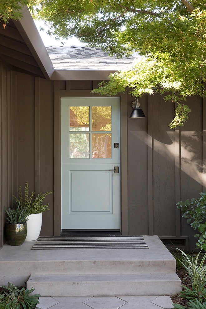 На фото: входная дверь среднего размера в стиле неоклассика (современная классика) с коричневыми стенами, бетонным полом, голландской входной дверью, зеленой входной дверью и серым полом с