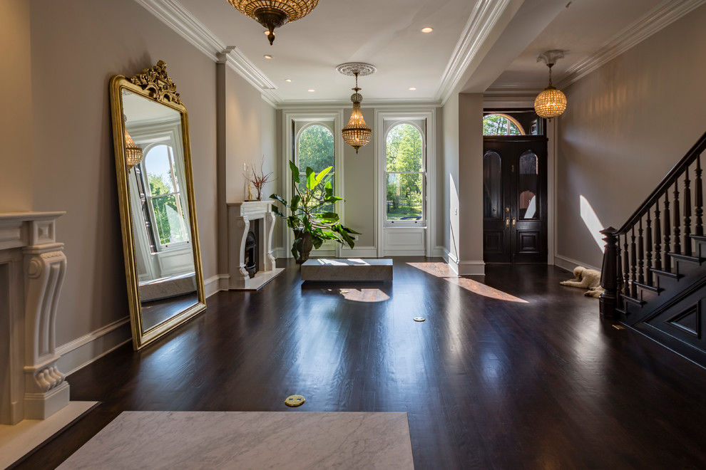 Large traditional foyer in St Louis with white walls, dark hardwood flooring, a double front door, a dark wood front door and brown floors.