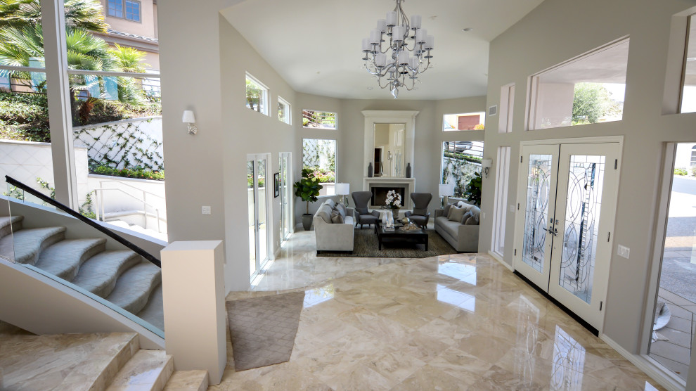 This is an example of a large contemporary foyer with grey walls, marble flooring, a double front door and a white front door.