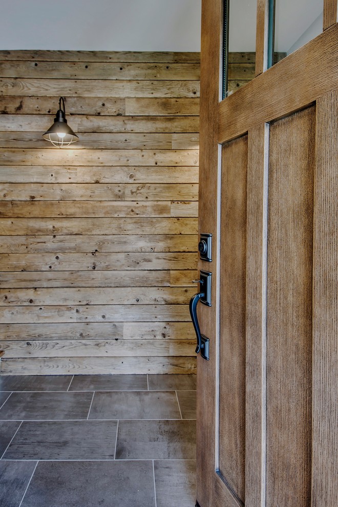 Foto di una grande porta d'ingresso country con pareti grigie, pavimento in gres porcellanato, una porta singola, una porta in legno bruno e pavimento grigio