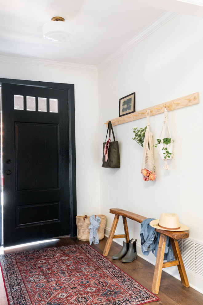 Modelo de distribuidor tradicional renovado pequeño con paredes blancas, suelo de madera en tonos medios, puerta simple, puerta negra y suelo marrón