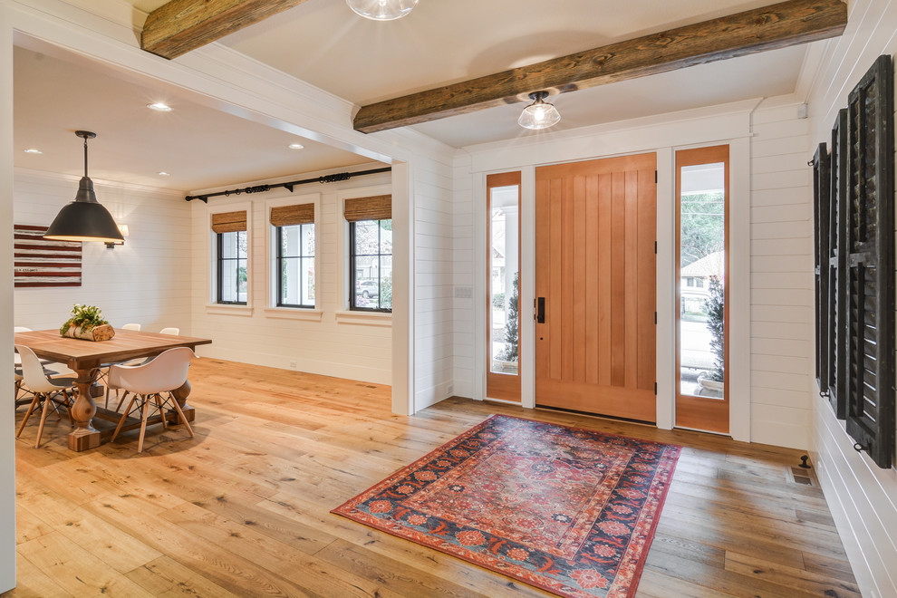 Country Eingang mit weißer Wandfarbe, braunem Holzboden, Einzeltür, hellbrauner Holzhaustür und braunem Boden in Portland