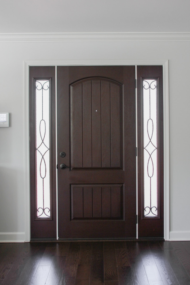 Foto di un piccolo ingresso o corridoio stile marino con pareti bianche, parquet scuro, una porta singola, una porta in legno scuro e pavimento marrone