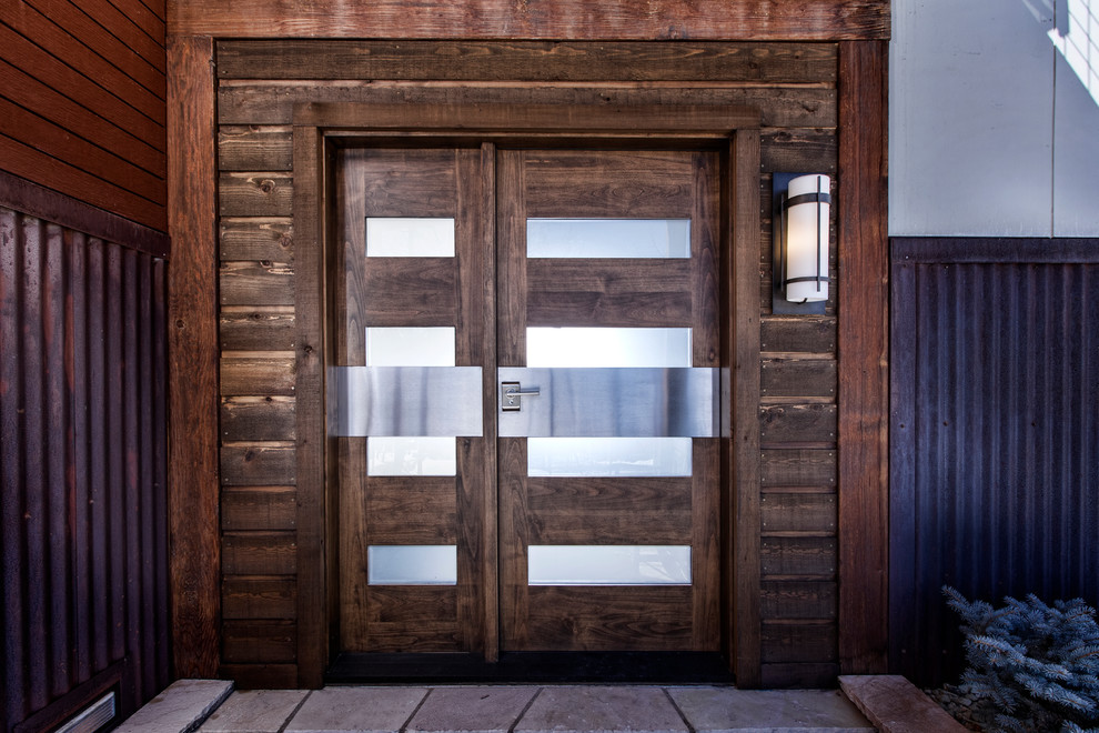 Foto de puerta principal rústica de tamaño medio con paredes marrones, suelo de cemento, puerta simple y puerta de madera oscura