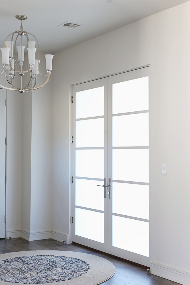 他の地域にあるラグジュアリーな広いコンテンポラリースタイルのおしゃれな玄関ロビー (クッションフロア、茶色い床、グレーの壁、白いドア) の写真