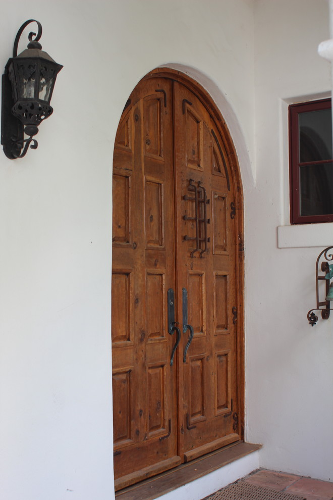 Modelo de entrada mediterránea con puerta de madera clara