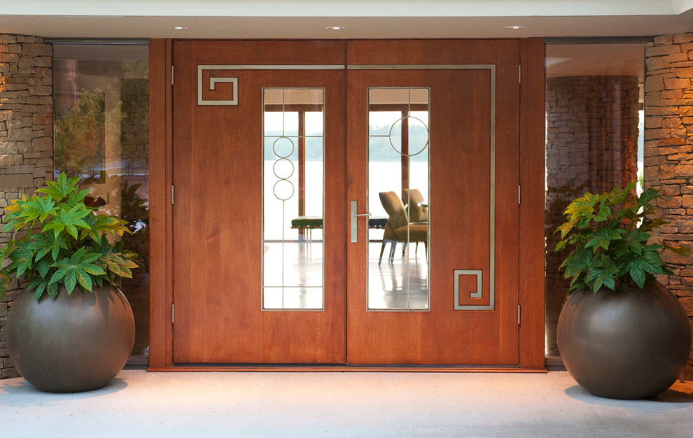 Esempio di una porta d'ingresso minimalista di medie dimensioni con una porta a due ante, una porta in legno bruno, pavimento in cemento, pareti bianche e pavimento grigio