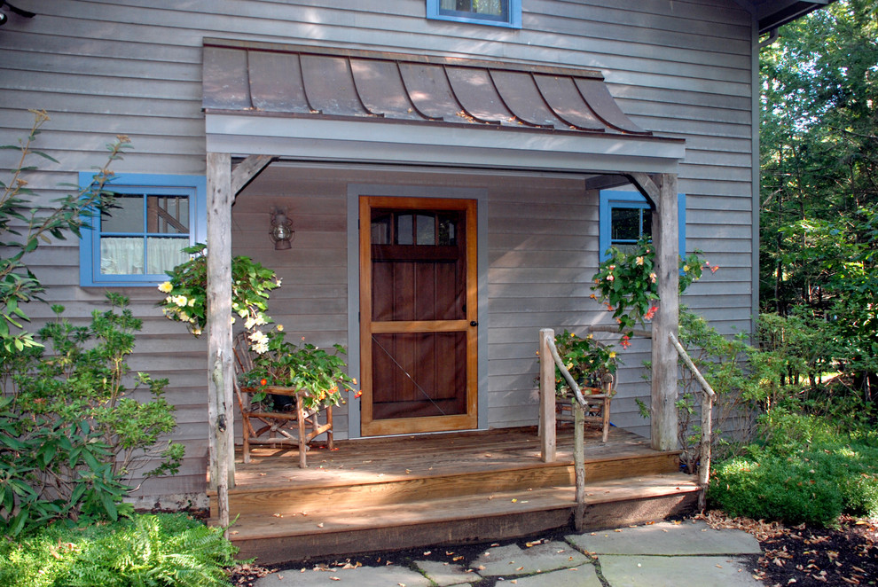 На фото: маленькая прихожая в стиле кантри с одностворчатой входной дверью и входной дверью из темного дерева для на участке и в саду с