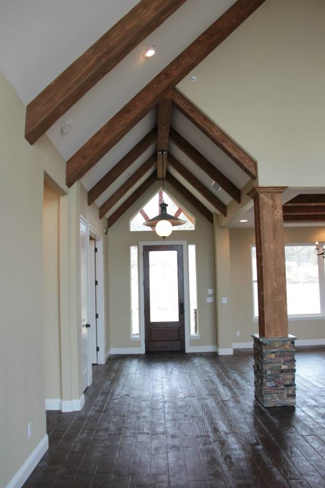 Mid-sized mountain style concrete floor entryway photo in Other with a dark wood front door