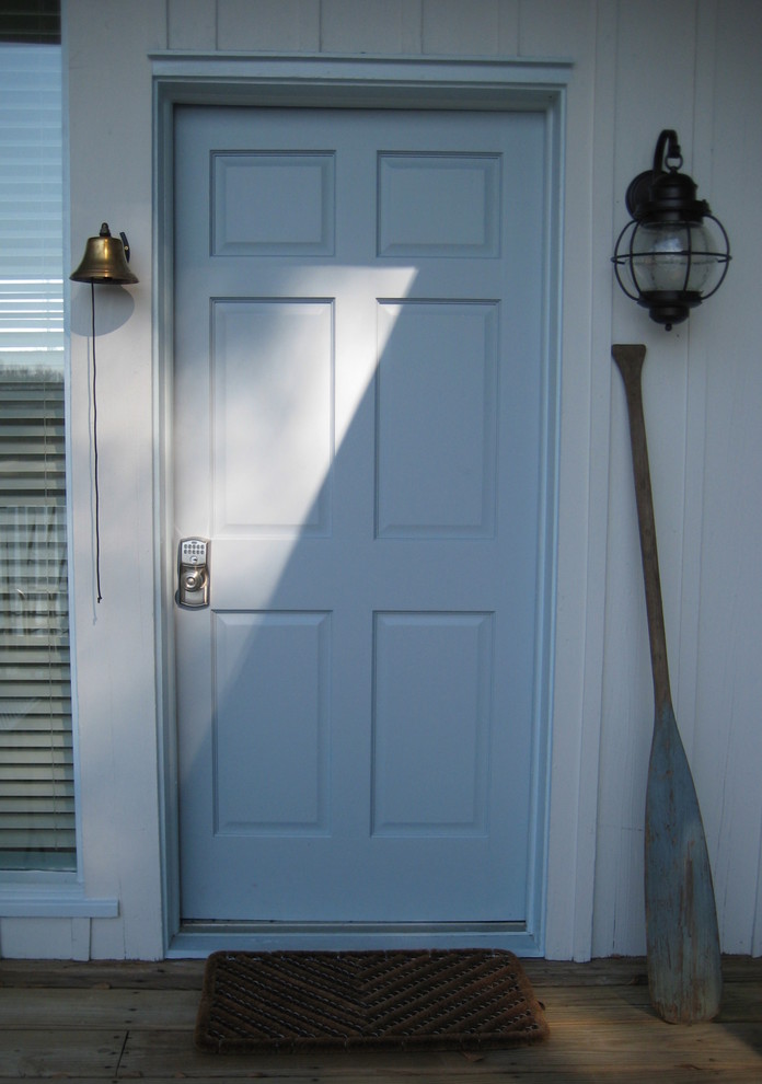 Immagine di una porta d'ingresso contemporanea di medie dimensioni con pareti blu, una porta singola, una porta blu, pavimento marrone e pavimento in legno massello medio