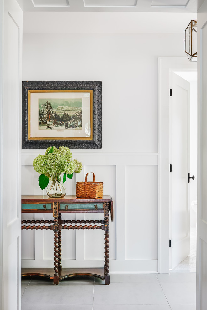 Example of a mid-sized beach style porcelain tile and gray floor entryway design in Toronto with white walls and a white front door