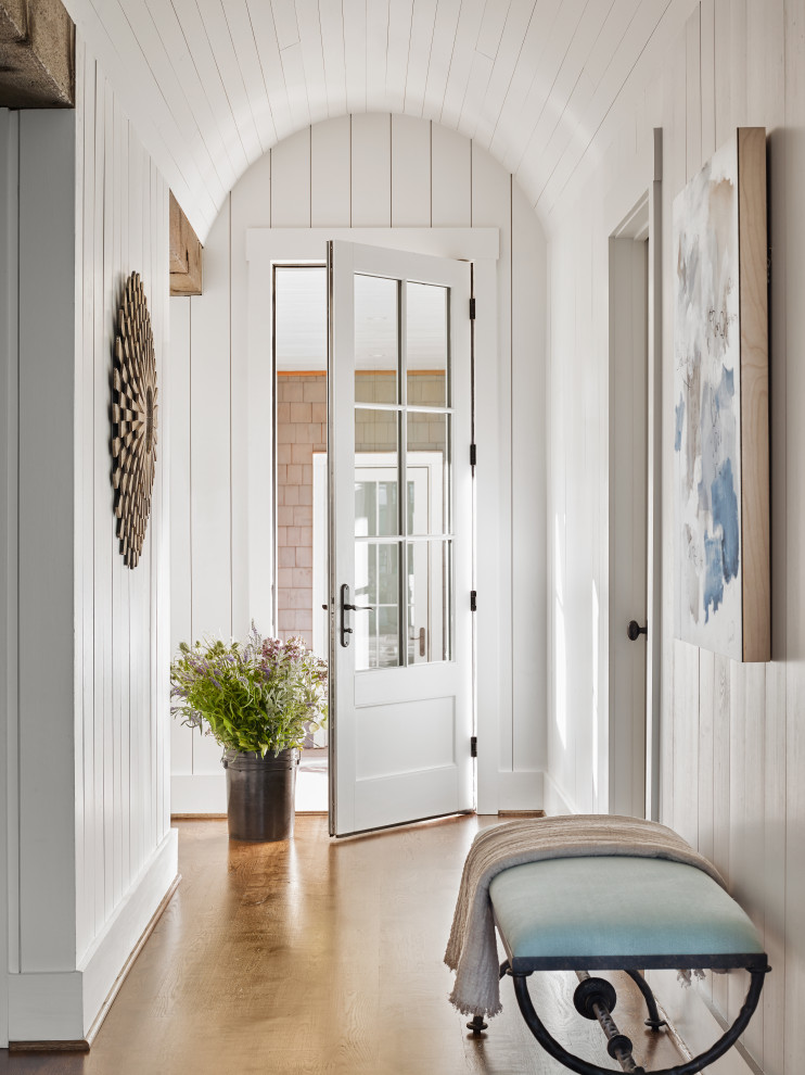 Exemple d'une entrée chic avec un couloir, un mur blanc, un sol en bois brun, une porte simple, une porte blanche, un sol marron, un plafond en lambris de bois, un plafond voûté et du lambris de bois.
