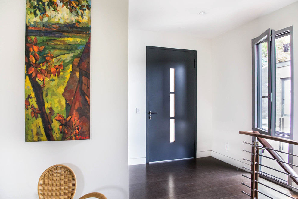 Ispirazione per una porta d'ingresso contemporanea con pareti bianche, parquet scuro, una porta singola, una porta nera e pavimento marrone