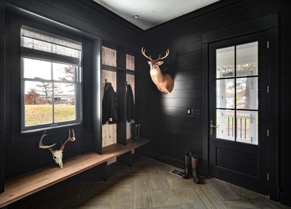 Country brown floor entryway photo in Nashville with black walls and a black front door