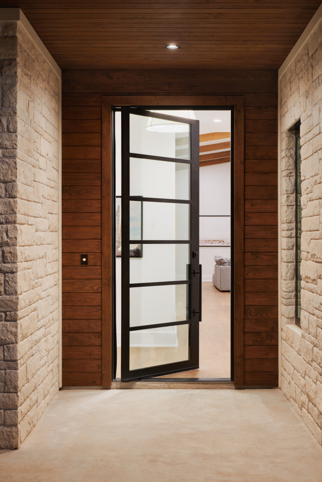 Diseño de puerta principal retro de tamaño medio con puerta pivotante, puerta metalizada, paredes blancas y suelo de madera en tonos medios