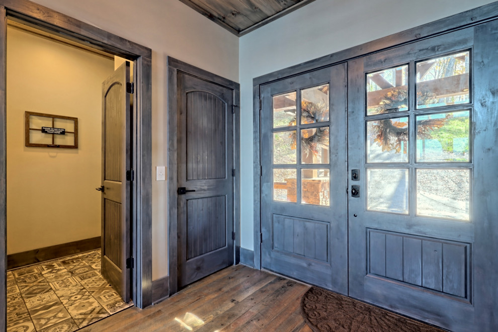 Idée de décoration pour une grande porte d'entrée craftsman avec un mur gris, un sol en bois brun, une porte double, une porte grise, un sol gris et un plafond en bois.