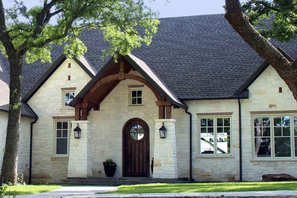 This is an example of a traditional entrance in Dallas with white walls, a single front door and a medium wood front door.