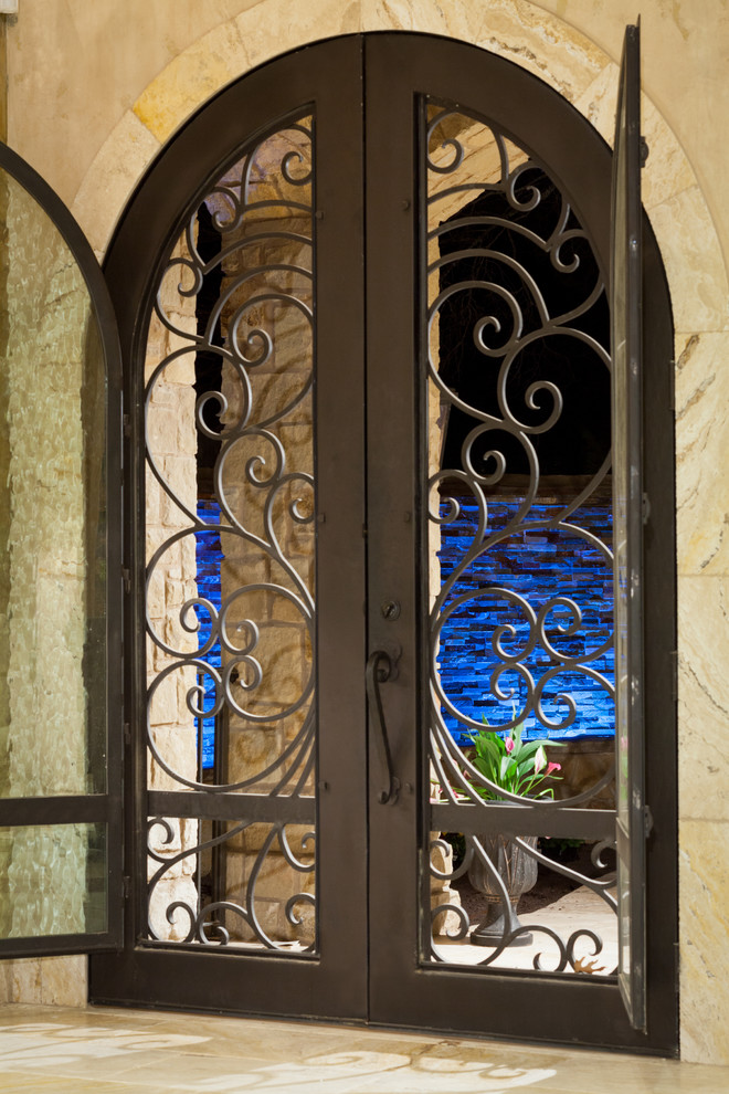 Foto de puerta principal mediterránea grande con suelo de travertino, puerta doble y puerta metalizada
