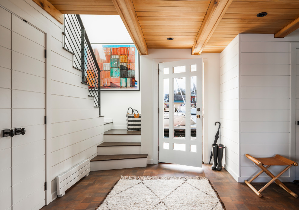 Maritimes Foyer mit weißer Wandfarbe, dunklem Holzboden, Einzeltür, weißer Haustür, braunem Boden, freigelegten Dachbalken, Holzdecke und Holzdielenwänden in Seattle