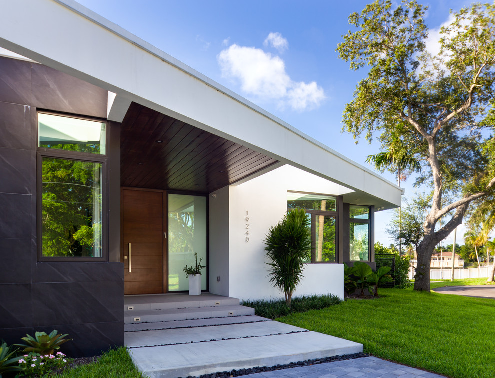 Moderne Haustür mit weißer Wandfarbe, Einzeltür, hellbrauner Holzhaustür und grauem Boden in Miami