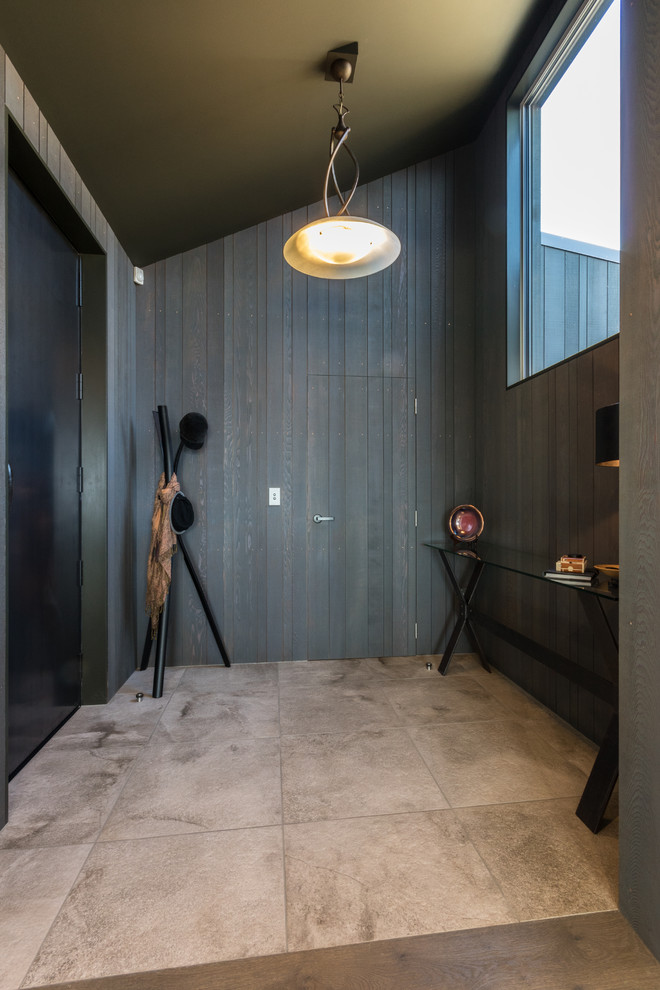Идея дизайна: фойе среднего размера в современном стиле с коричневыми стенами, полом из керамогранита, одностворчатой входной дверью, черной входной дверью и бежевым полом