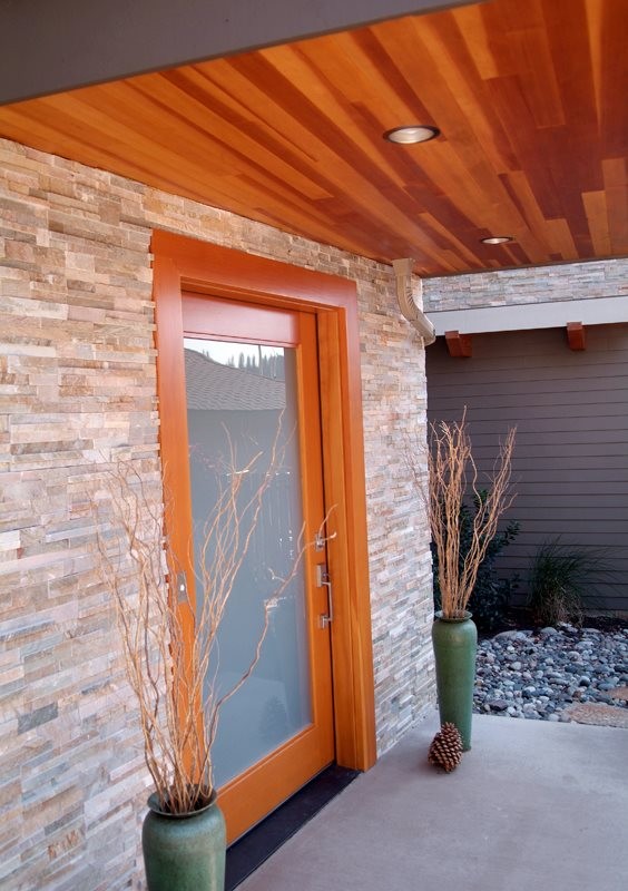 Imagen de puerta principal actual de tamaño medio con suelo de cemento, puerta simple y puerta de madera en tonos medios